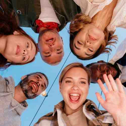 A group of friends waving at the camera.