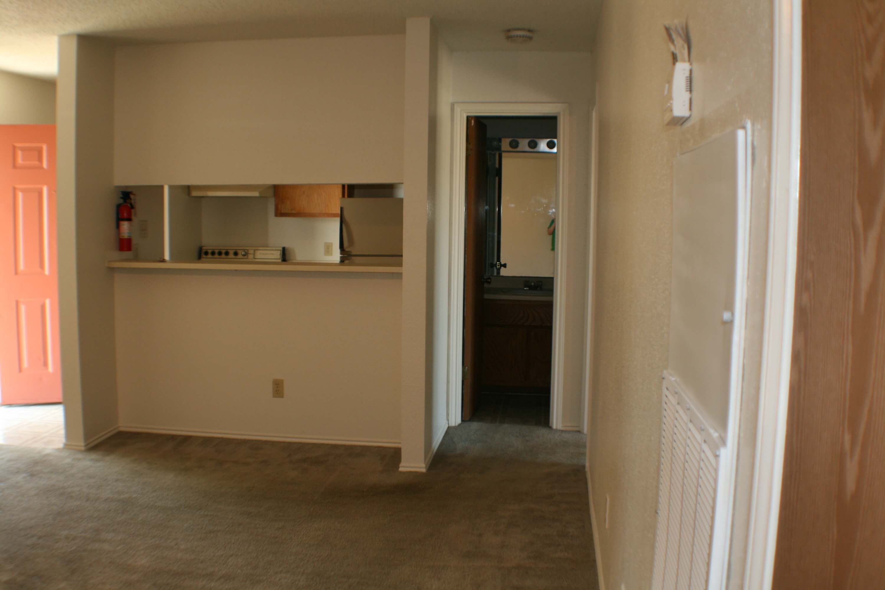 The hallway leading to the living room, kitchen, bathroom, and bedrooms within a unit at Stadium View Apartments.