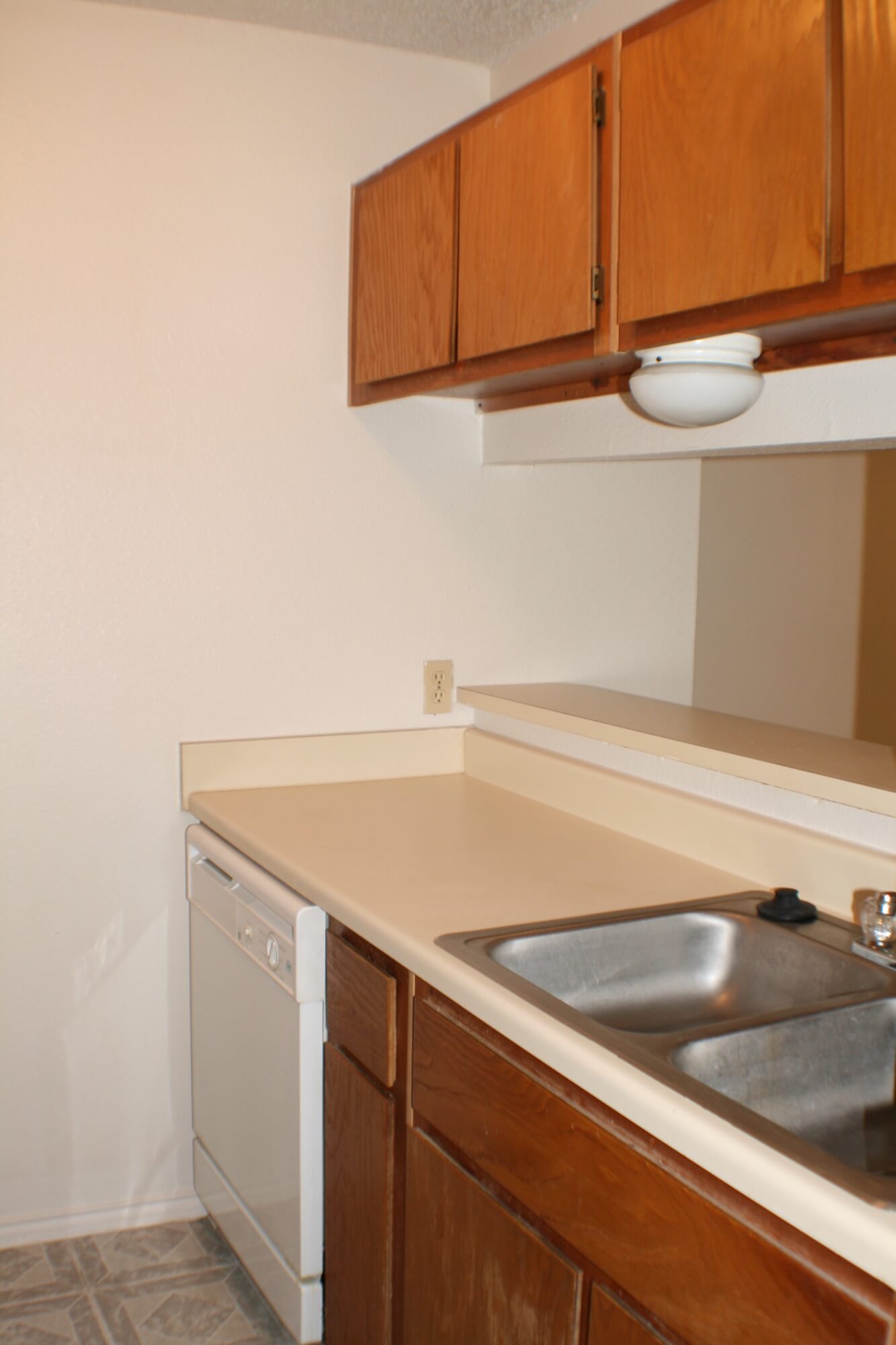 Kitchen countertops and a galley window seeing into the living room at Stadium View Apartments.