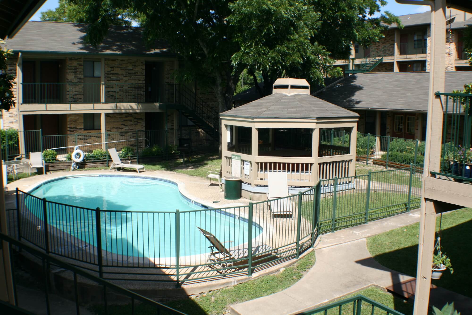 Stadium View Apartments bright blue pool and gazebo with bbq area.